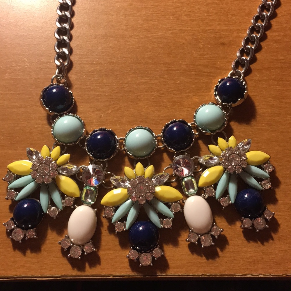A silver statement necklace with mint and navy.